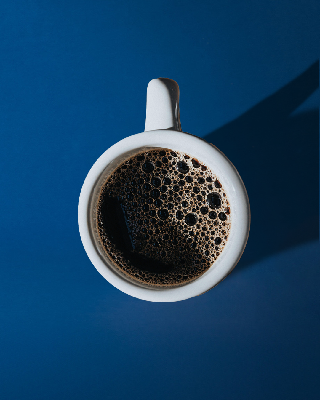 Brewed Fresh After Hours Coffee in a white mug, on a blue colour table